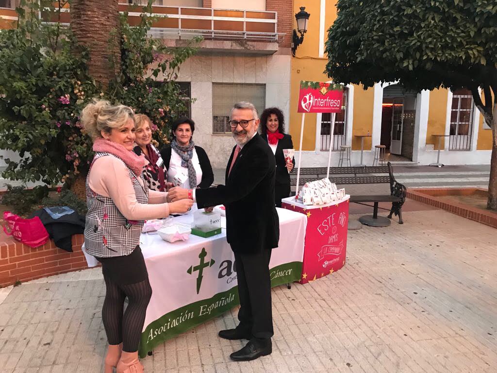 El alcalde de Bonares, tras recoger los cartuchos de fresas y hacer entrega del donativo para la AECC, recibió la pulsera solidaria aportada por Fundación Caja Rural del Sur.